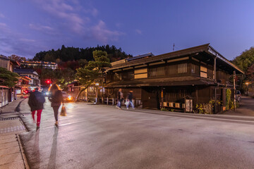 Takayama's historic old town at twilight on night sky. Traditional architecture wooden houses with light up at dusk. Beautiful town in Takayama, Gifu Prefecture, Japan.