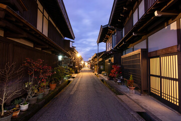 Naklejka na ściany i meble Takayama's historic old town at twilight on night sky. Traditional architecture wooden houses with light up at dusk. Beautiful town in Takayama, Gifu Prefecture, Japan.