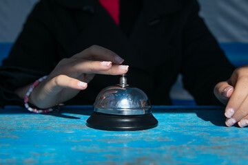Woman ringing service bell on the table.