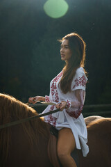Young women ride horses in national Ukrainian dresses in the Carpathian mountains. Photo session with horses in the mountains. Ukrainian culture concept