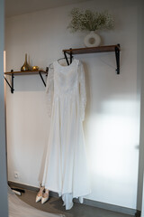 a white wedding dress hanging on a hanger