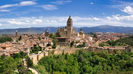 Fototapeta na wymiar an aerial view of the town with Segovia Cathedral and mountains in spain