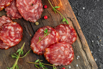 Dry sausage with thyme on a wooden board. banner, menu, recipe place for text, top view