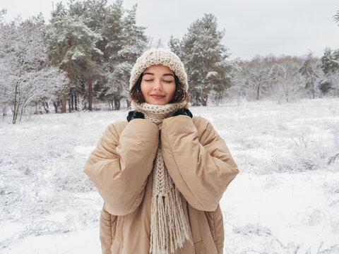 Winter girl, young woman in snowing wintertime outdoor in forest. High quality photo