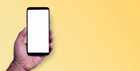 Hand holding a smartphone with a blank white screen on a yellow background Copy area, text area