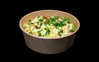 salad in a bowl on a black background.