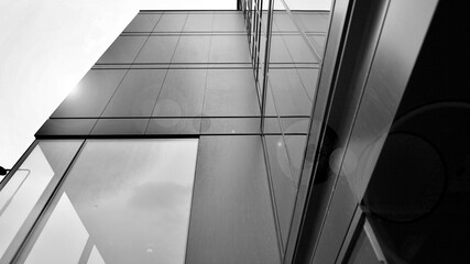 A view at a straight facade of a modern building with a dark grey facade. Dark grey metallic panel facad. Modern architectural details. Black and white.