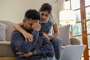 Indian couple sitting together indoors in the home house, calculating finances at home, looking seriously in documents bills payment online - obrazy, fototapety, plakaty