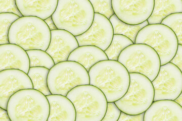 Cucumber slices pattern. Pile of round cucumber cuts texture. Green vegetable background. Cucumber cross section.