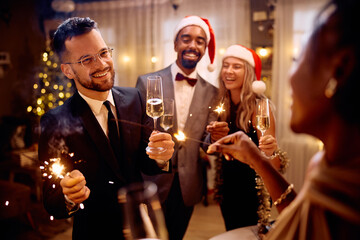 Happy man celebrating New Year and having fun with friends at home.