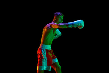Aggressive shirtless boxer, mixed martial art fighter preparing to fight against black mode...