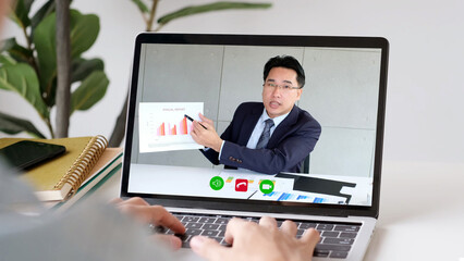 Fototapeta na wymiar Video conference, Work from home, Asian man making video call to business team with virtual web, Online consultation business