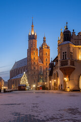 St Mary's church and Cloth Hall on snow covered Main Square in winter Krakow, illuminated in the night.