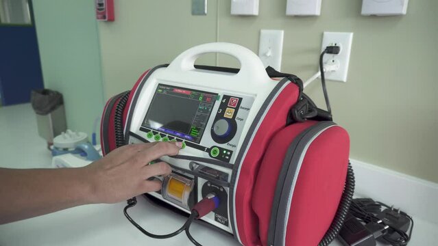 Male doctor demonstrating a defibrillation machine at the hospital