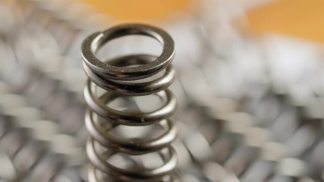 Spinning showcase of single spring coil, interconnected component. Macro, closeup