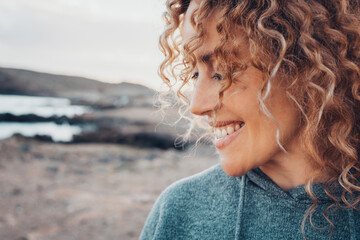 Close up side view portrait of happy woman with serene expression smiling and enjoying life outdoor leisure activity alone. Adult caucasian female people happy thoughts and enjoying life in outdoors - obrazy, fototapety, plakaty