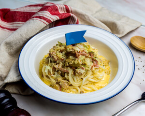 Grilled Carbonara Chicken with Fish Udon served in plate isolated on napkin side view italian cuisine on table