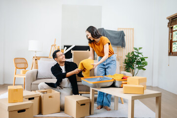 Young couple with big boxes moving into a new house, new apartment for couple, young man and woman helping to lift boxes on sofa for the new home, Moving house..