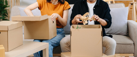 Happy asian young attractive couple man and woman with big boxes moving into a new house, new...