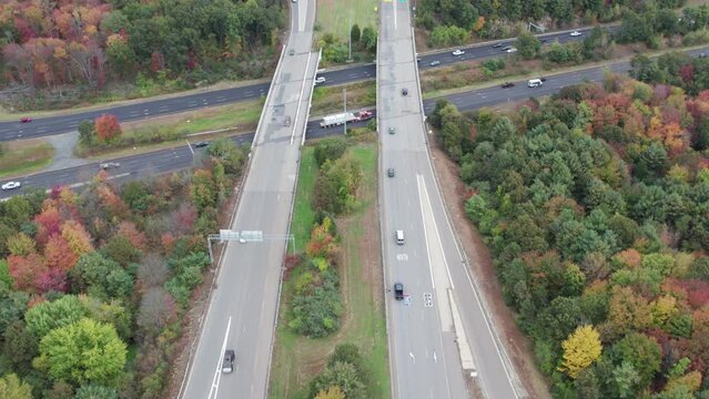 Drone footage over Donald Lynch Boulevard and Route 495 in Marlboro, Massachusetts. Camera tilts up to reveal overpass crossing state highway.