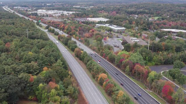 Drone footage over Donald Lynch Boulevard in Marlboro, Massachusetts. Fall foliage and directions of traffic extend west.