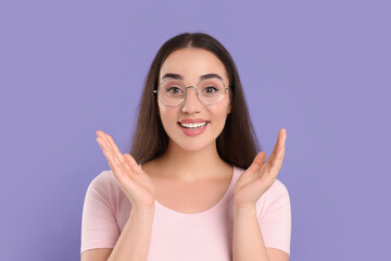 Beautiful woman wearing glasses on violet background