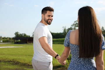 Obraz premium Romantic date. Beautiful couple walking outdoors on sunny day