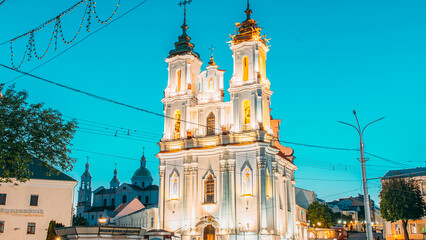 Vitebsk, Belarus. View On Church Of Resurrection Of Christ On Market Square In Evening Or Night Illuminations. Bold Colors. Famous Landmark. Travel Destinations. Traffic Car Lights Motion.