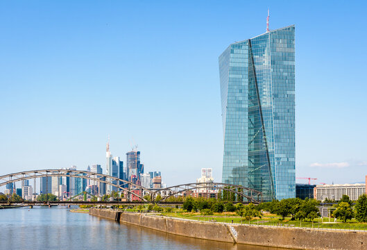 Frankfurt am Main, Germany - Aug. 20, 2023: The Skytower building, seat of the European Central Bank (ECB) since 2015, on the Main river with the skyscrapers of the financial district in the distance.