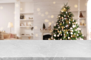 Light grey marble table in room with Christmas tree. Space for design