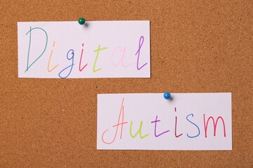 Cards with words Digital Autism pinned on corkboard