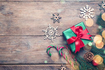 Beautiful Christmas composition with gift box, festive decorations and space for text on wooden table, flat lay. Bokeh effect