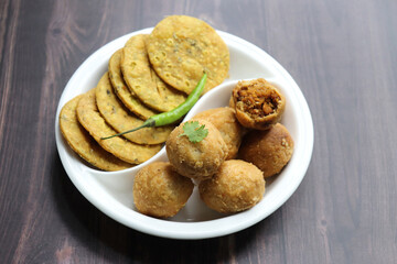 Indian popular snacks plate Dry Kachori and methi mathri. made using maida flour, a spicy mix of gram flour, sev, Lentils, Tamarind chutney and other Indian spices. A popular tea time snack. 