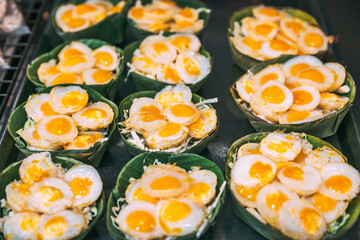 Fried quail egg in banana leaf at shopping street food market Bangkok Thailand