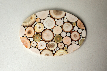 Background for design. Wooden stand made of round wood cuts on beige concrete background. Top view