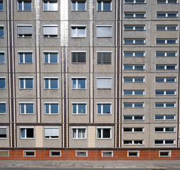 Obraz premium Facade of the socialistic panel grey with orange old building with windows in Berlin, Germany