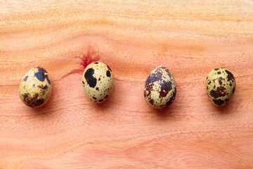 Quail eggs on a wooden background. Quail eggs in a row