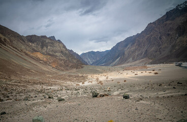 Valley between mountains on a cloudy day. A Dried river trains of Shyok river in Nubra Valley in...
