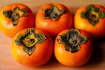 Ripe persimmons on a wooden background. Selective focus.