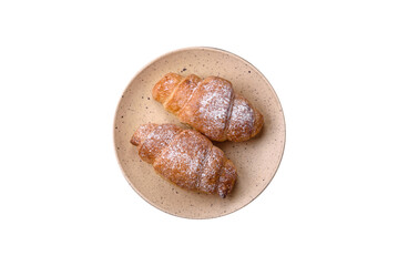 Delicious fresh sweet crispy croissants with chocolate cream on a ceramic plate