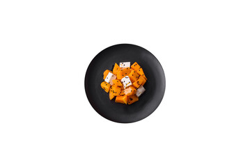 Delicious juicy salad of diced grilled pumpkin with feta cheese, spices and sesame seeds