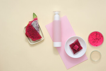 Fresh dragon fruit with display props simulating a vegan cosmetics advertisement with a beige background. Creative space for advertising. Copy space.