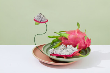 Two plates are stacked on top of each other, the top is decorated with fresh dragon fruit. White table, pastel background. Food and cosmetics with ingredients from fresh dragon fruit.