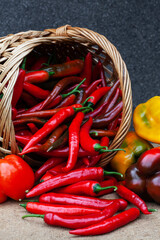 many red peppers in a basket on a dark background