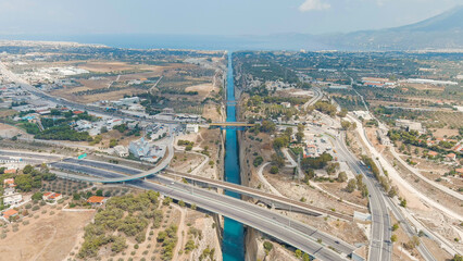 Corinth Canal, Greece. The Corinth Canal is a sluiceless shipping canal in Greece, connecting the Saronic Gulf of the Aegean and the Gulf of Corinth of the Ionian Sea, Aerial View