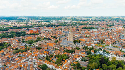 Bruges, Belgium. Church of Our Lady - Gothic church from the 13th century. Panorama of the city center from the air. Cloudy weather, summer day, Aerial View