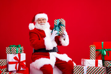 Photo of old bearded senior man saint nicholas showing gift new year preparation magic miracle advent isolated on red color background