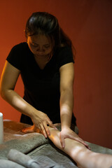 A masseuse gives a massage in a dark room