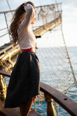 a beautiful girl in a pirate costume on the deck of a ship.