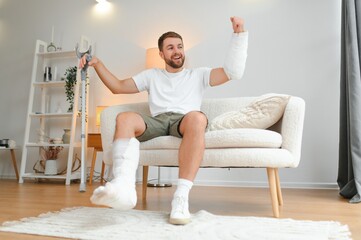 Happy man recovery from accident fracture broken bone injury with leg and arm. Social security and...